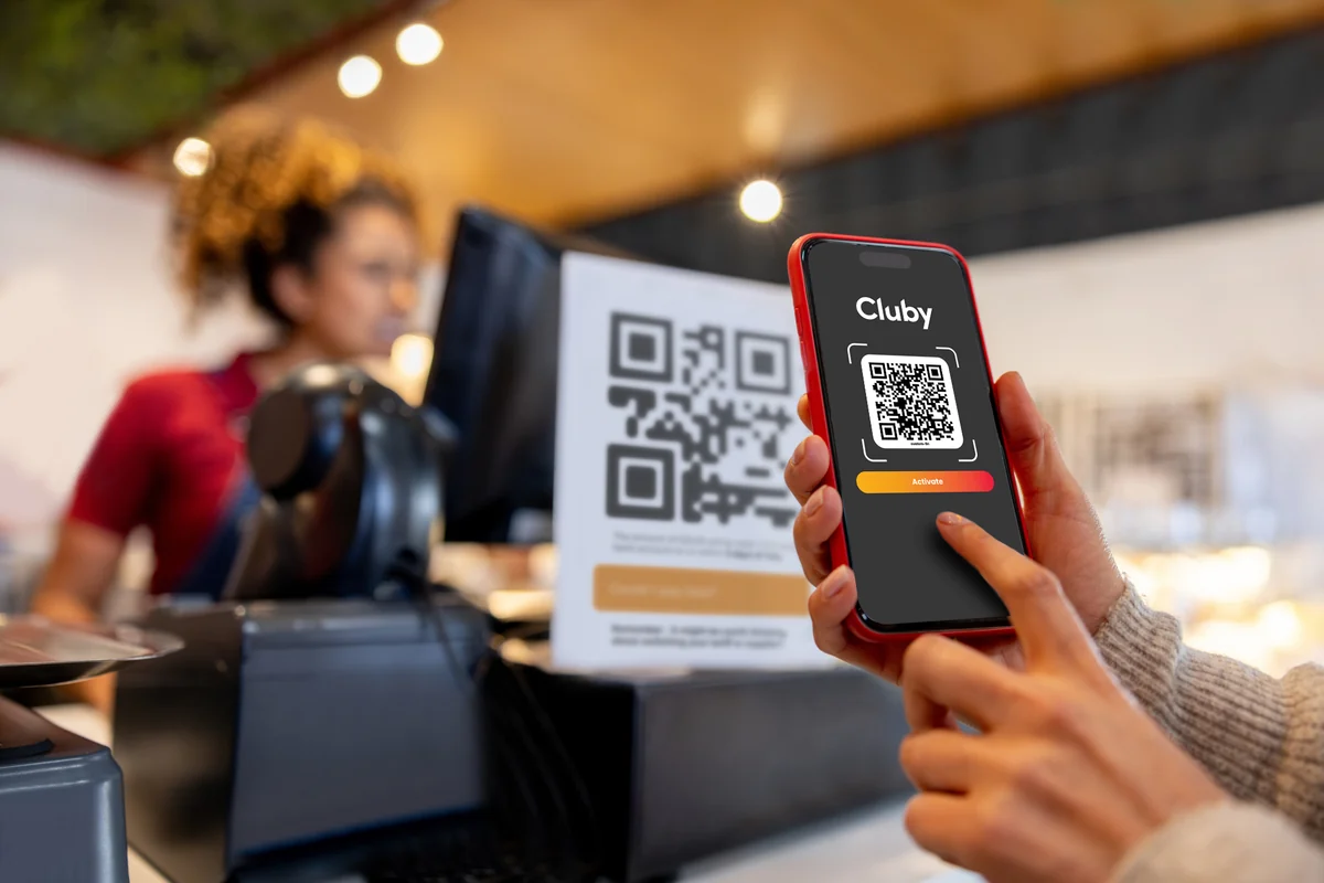 A customer activating a Cluby benefit on their phone at the restaurant counter